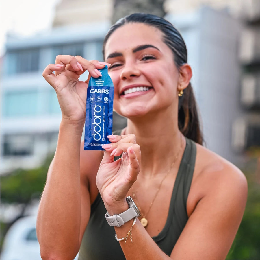 Atleta com o sachê de Carbs Gel na mão
