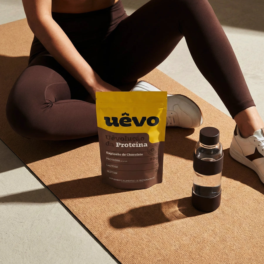 Pouch de Proteína Uêvo no tapete de treino, ao lado da garrafa